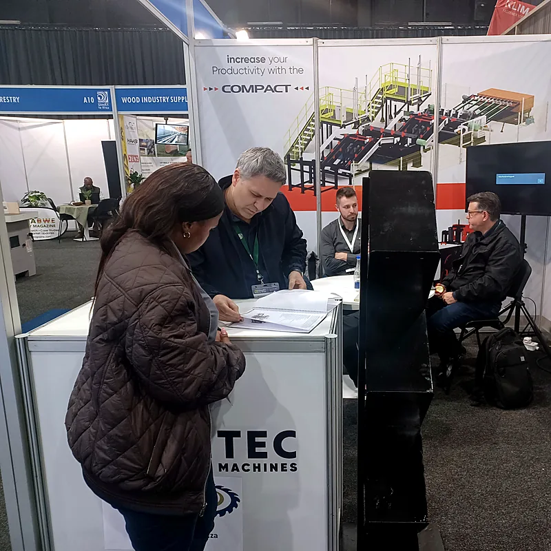 NEWSAW and Vantec representatives reviewing equipment information with a visitor at WoodEX 2026